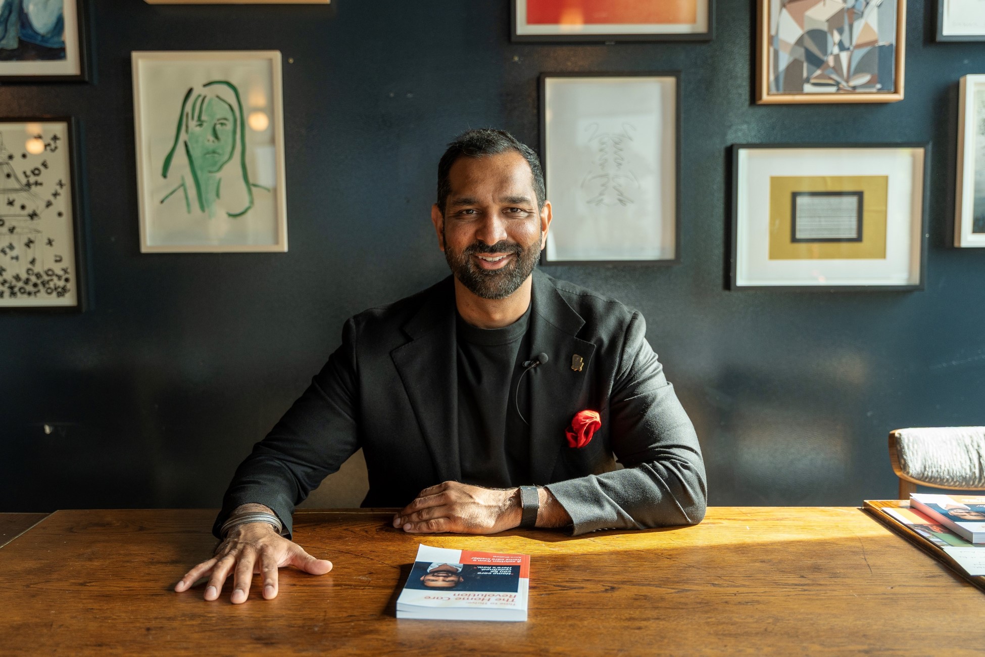 Walfinch CEO Amrit Dhaliwal sitting at a table with his book Time to Thrive