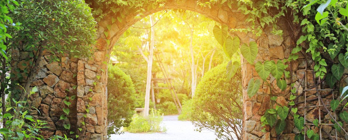 Stone archway in a sunlit garden, from The Archway Foundation website
